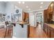 Open kitchen featuring wooden cabinetry, breakfast bar, stainless steel appliances, and hardwood flooring at 1425 Princess Anne Rd, Cary, NC 27607