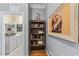 Hallway view to laundry room with shelves, appliances, and wall decor at 1425 Princess Anne Rd, Cary, NC 27607