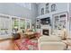 Bright living room featuring hardwood floors, a fireplace, and large windows overlooking the greenery at 1425 Princess Anne Rd, Cary, NC 27607