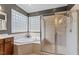 Main bathroom featuring a glass enclosed shower, soaking tub, and corner windows for natural light at 1425 Princess Anne Rd, Cary, NC 27607