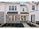 Charming two-story townhouse showcasing stone accents, a black awning, and a welcoming entrance at 1426 Cooper St, Sanford, NC 27330