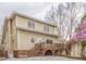 Charming two-story home with a spacious wooden deck and stairs on a gravel driveway, next to a blossoming tree at 1426 N Roxboro St, Durham, NC 27701