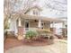 Charming exterior showcasing a covered porch with brick pillars and a well-maintained landscaped yard at 1426 N Roxboro St, Durham, NC 27701