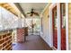Covered porch detail highlighting brick pillars, a ceiling fan, and a view of the landscaped surroundings at 1426 N Roxboro St, Durham, NC 27701