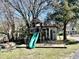 Large wooden playset with slide and swings surrounded by trees and a small shed at 1426 N Roxboro St, Durham, NC 27701