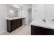 Bathroom featuring dual sinks with dark wood cabinets, white countertops, and a large mirror at 1430 Cooper St, Sanford, NC 27330