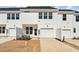 New townhouse boasts bright white siding, a one car garage, and a welcoming front yard at 1430 Cooper St, Sanford, NC 27330