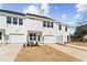 Bright white townhouse features a one car garage, manicured lawn, and inviting curb appeal at 1430 Cooper St, Sanford, NC 27330