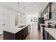 Modern kitchen featuring a large island with a sink, stainless steel appliances, and sleek dark cabinetry at 1430 Cooper St, Sanford, NC 27330