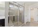Glass enclosed shower with tile surround and built-in bench; linen closet in view at 1432 Cooper St, Sanford, NC 27330
