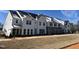 Townhomes with a mix of white siding, stone, driveways, and grassed common space are ready to be enjoyed at 1432 Cooper St, Sanford, NC 27330