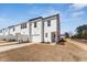 Townhomes with white siding, garages, driveways, and grassed common space are ready to be enjoyed at 1432 Cooper St, Sanford, NC 27330
