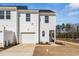 Townhome garage and drive, with white siding and freshly planted landscape are ready to be enjoyed at 1432 Cooper St, Sanford, NC 27330