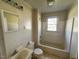 Bathroom with a tub, toilet, sink and a window providing natural light at 148 Baptist Church Rd, Henderson, NC 27537