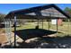 A metal carport is built to protect vehicles from the outdoor elements, on a grass and gravel lot at 148 Baptist Church Rd, Henderson, NC 27537