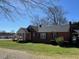 Charming one-story red brick home with a welcoming front porch and well-manicured lawn at 148 Baptist Church Rd, Henderson, NC 27537