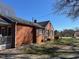A red brick home with a covered porch and well maintained lawn and landscaping on a sunny day at 148 Baptist Church Rd, Henderson, NC 27537