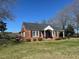 Well-maintained brick home with a charming front porch and mature trees at 148 Baptist Church Rd, Henderson, NC 27537