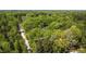 Aerial view showing the home nestled among lush greenery with a long driveway leading through the wooded landscape at 149 Amber Rd, Timberlake, NC 27583