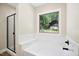 Modern bathroom with a tub, shower, and black hardware. Window with backyard view at 149 Amber Rd, Timberlake, NC 27583