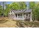 Beautiful home exterior featuring a welcoming front porch, mature trees, professional landscaping, and a lovely yard at 149 Amber Rd, Timberlake, NC 27583