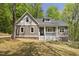 Charming home with a covered porch and a well-manicured lawn surrounded by lush trees at 149 Amber Rd, Timberlake, NC 27583