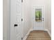 Hallway with wood flooring, a door leading outside and a door to a bedroom at 149 Amber Rd, Timberlake, NC 27583