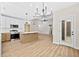 Spacious kitchen featuring stainless steel appliances, white cabinets, a center island, and a sleek, modern chandelier at 149 Amber Rd, Timberlake, NC 27583