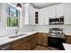 Modern kitchen with stainless steel appliances, a stylish faucet, white subway tile backsplash, and elegant two-tone cabinets at 149 Amber Rd, Timberlake, NC 27583
