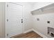 Clean laundry room with white door, light gray walls, and wood-look flooring at 149 Amber Rd, Timberlake, NC 27583
