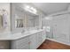 Bathroom featuring double vanity, large mirror, shower, and wood flooring at 1613 Bulon Dr, Cary, NC 27518