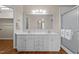 Bathroom featuring double vanity, large mirror, shower, and wood flooring at 1613 Bulon Dr, Cary, NC 27518