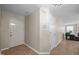 Hallway with neutral walls, tiled floors, and multiple doors leading to different parts of the house at 1613 Bulon Dr, Cary, NC 27518