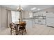Bright eat-in kitchen with white cabinets, stainless steel appliances, chandelier, and a wooden table with four chairs at 1613 Bulon Dr, Cary, NC 27518