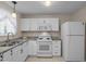 Bright kitchen with white cabinetry, granite countertops and stainless steel appliances at 1613 Bulon Dr, Cary, NC 27518