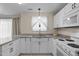 A well-lit kitchen features white cabinets, granite countertops, stainless steel appliances, and tile flooring at 1613 Bulon Dr, Cary, NC 27518