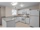 A well-lit kitchen features white cabinets, granite countertops, stainless steel appliances, and tile flooring at 1613 Bulon Dr, Cary, NC 27518