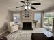 Cozy living room with fireplace, ceiling fan, and sliding glass doors to the outside at 1613 Bulon Dr, Cary, NC 27518