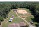 Expansive aerial view featuring equestrian facilities, paddocks, outbuildings, and a home surrounded by wooded landscape at 195 Falcon Ln, Rougemont, NC 27572