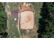 Aerial view of a large equestrian arena with stables and paddocks, surrounded by lush greenery at 195 Falcon Ln, Rougemont, NC 27572