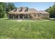 Inviting front exterior with a sprawling lawn, covered porch, stone accents, and rocking chairs at 195 Falcon Ln, Rougemont, NC 27572