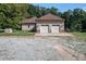 Attached two-car garage with white doors complementing the home's exterior, set on a gravel driveway at 195 Falcon Ln, Rougemont, NC 27572