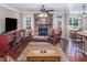 Spacious living room with stone fireplace, leather chair, wood floors, and views into kitchen at 195 Falcon Ln, Rougemont, NC 27572