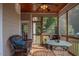 A screened in porch features a wooden ceiling, furniture, and views of the wooded property at 195 Falcon Ln, Rougemont, NC 27572