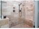 A glass enclosed shower boasts updated fixtures and eye-catching neutral toned tiles, including tiled inset shelves at 195 Falcon Ln, Rougemont, NC 27572