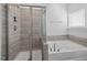 Luxurious bathroom featuring a separate shower and soaking tub, enhanced by elegant tile work and natural light at 204 Cassada Ct, Holly Springs, NC 27540