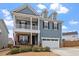 Charming two-story home features a welcoming front porch, a two-car garage, and classic blue siding at 204 Cassada Ct, Holly Springs, NC 27540