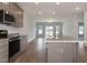Open kitchen with a large island featuring granite countertops, stainless steel appliances, and a view of the living area at 210 Cason Dr, Gibsonville, NC 27249