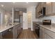 Modern kitchen featuring an island, stainless steel appliances, granite countertops, and a pantry door at 210 Cason Dr, Gibsonville, NC 27249