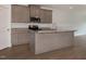 Modern kitchen with a large island, granite countertops, stainless steel appliances and wood grain floors at 210 Cason Dr, Gibsonville, NC 27249